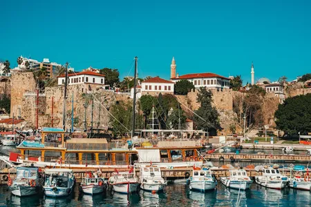 Colourful traditional wooden boats moored in Antalya's historic Roman harbour — the picturesque old port that dental tourism patients visit during their recovery days in Antalya